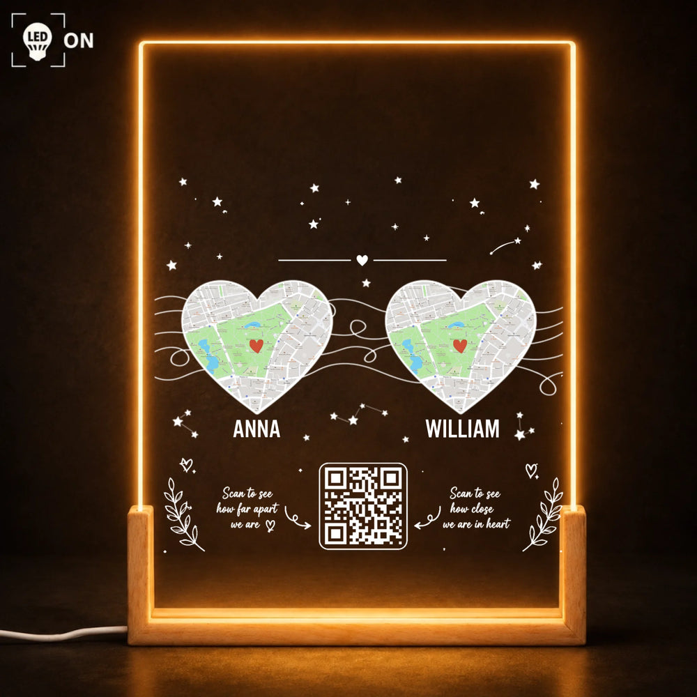 Two heart-shaped location maps and names on an acrylic light with a wood base